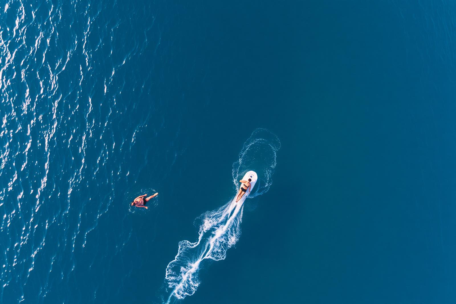 Aerial view of open water with swimmer